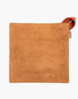 Tan suede leather hot pad with a Terracotta hanging strap on a white background